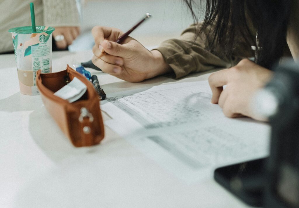 A student focuses on writing notes in a Tokyo classroom, capturing the essence of academic life.